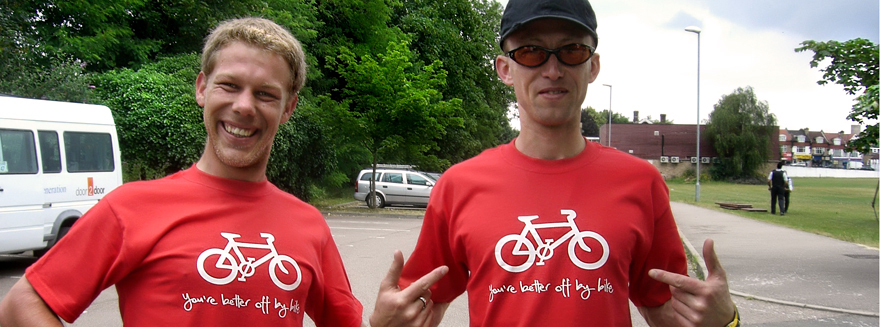 Two Bugbugs riders showing off their T-Shirts, with the slogan 'you're better off by bike'